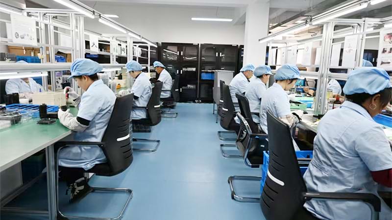 Night vision assembly workshop with technicians building NVG optics